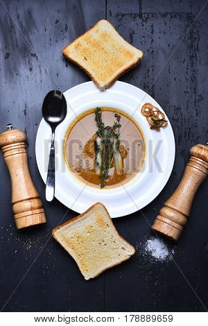 Cream Soup Brown Color With Fish, Toast, Pepperbox, Thyme, Saltcellar