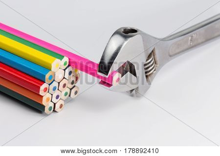Adjustable wrench clamps a pink pencil from a beam