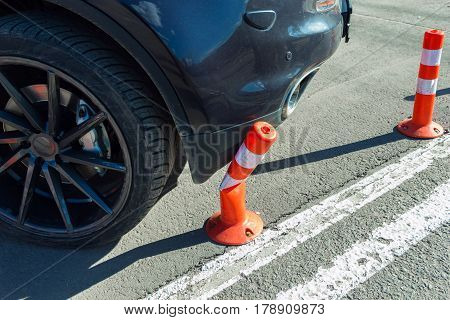 Car collide and breking smal orange plasticl traffic cone with stripes