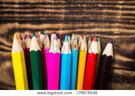color pencil in a cup on wooden background