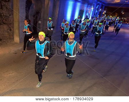 STOCKHOLM SWEDEN - MAR 25 2017: Group of runners from above in blue reflex vest in a tunnel with blue light in the Stockholm Tunnel Run Citybanan 2017. March 25 2017 in Stockholm Sweden