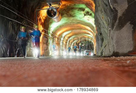 STOCKHOLM SWEDEN - MAR 25 2017: Group of ghost like runners in a tunnel with green and orange light in the Stockholm Tunnel Run Citybanan 2017. March 25 2017 in Stockholm Sweden