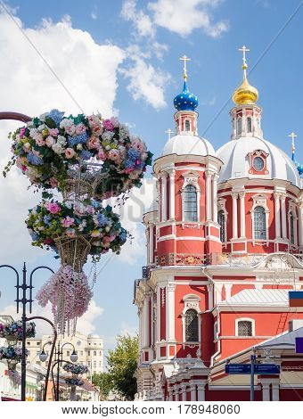 The baroque church of Saint Clement of Rome in Moscow with flowers on the foreground.