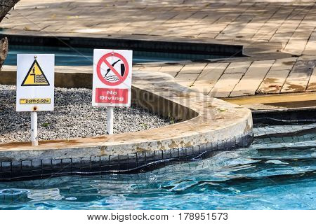 Closeup of no diving and depth signs in swimming pool