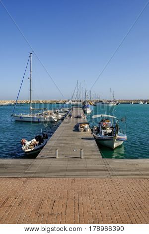 Wooden jetty at the marina in the fishing village of Zygi, Cyprus.  Spring time shot on a sunny afternoon.