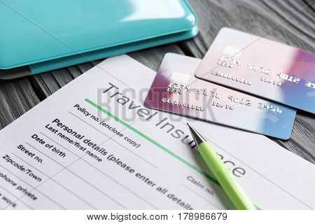 Travel preparation concept with insurance application form and credit cards for online payment on wooden table background
