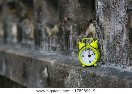 classic green alarm clock afternoon time on drity wall background