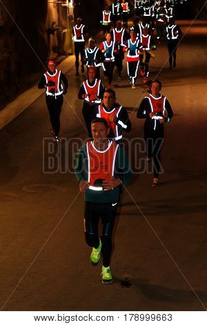 STOCKHOLM SWEDEN - MAR 25 2017: Group of runners in reflex vest in a dark tunnel in the Stockholm Tunnel Run Citybanan 2017. March 25 2017 in Stockholm Sweden