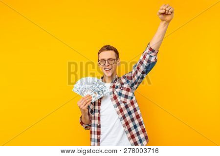 Screaming Man In A Plaid Shirt Holds Money In His Hands And Looks Into The Camera On A Yellow Backgr