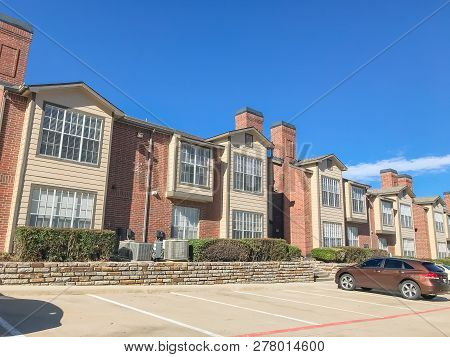 Exterior Of Apartment Building With High Retaining Wall In Subur