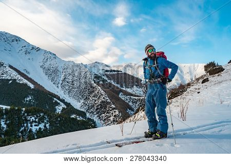 A Man Is Engaged In Ski Touring On Splitboarding. Sunrise In The Mountains. Kyrgyzstan