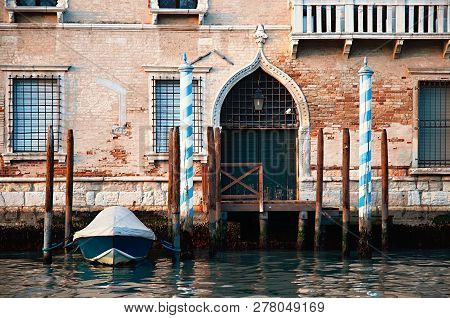 Detailled View Of An Old Venetian Palazzo With A Parked Boat. Picture Taken From A Tourist Boat On T