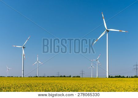 Modern Wind Turbines And Flowering Oilseed Rape Seen In Germany
