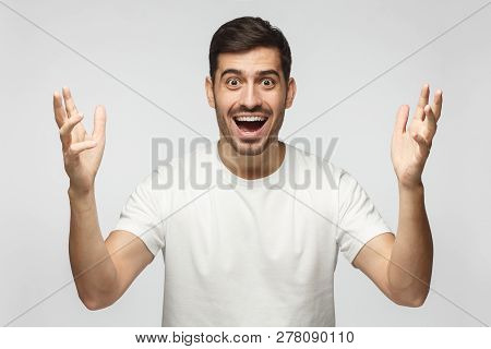 Young Happy Crazy Man Showing Big Size Gesture With Hands, Emphasizing Great Amount Of Something