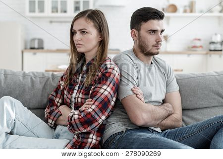 Young Couple Experiencing Problems In Relations Sitting Next To Each Other But Unwilling To Communic