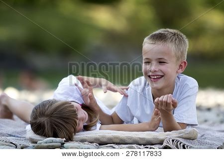 Two Young Happy Cute Blond Laughing Children, Boy And Girl, Brother And Sister Having Fun On Pebbled