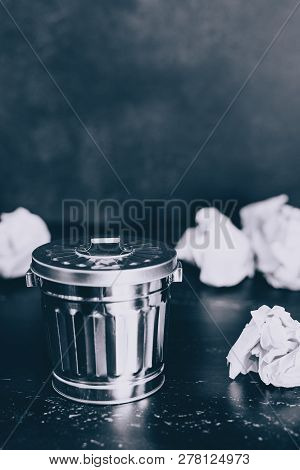 Garbage Bin On Desk Setting And Scrunched Paper Balls Around It, Concept Of Drafting And Struggling 