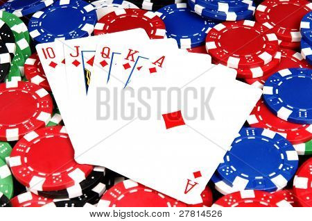 Parmi les plus élevés des mains au poker une Quinte Flush royale diamants sur un lit de jetons de poker