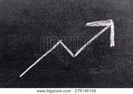 White Chalk Hand Drawing In Uptrend Arrow Shape On Black Board Background