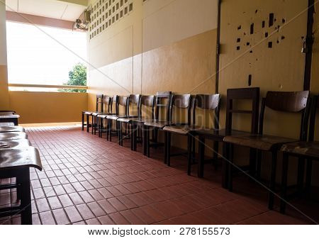 Unused Student Chair In Front Of The Broken Door Of An Old Classroom