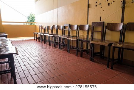 Unused Student Chair In Front Of The Broken Door Of An Old Classroom