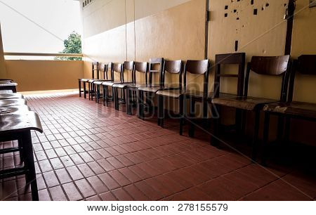 Unused Student Chair In Front Of The Broken Door Of An Old Classroom