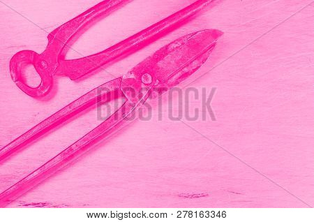 Scissors For Metal And Pincers Lay On Sheet Of Alluminium. Pink Toned. Concept Of Feminism.