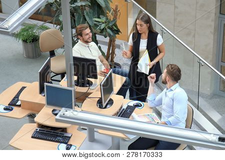 Top View Of Young Modern Colleagues In Smart Casual Wear Working Together While Spending Time In The