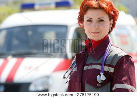 Positive Paramedic Medical Technician With Phonendoscope At Emergency Car Background