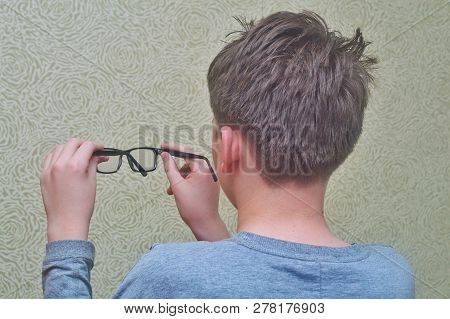 The Boy Holds Glasses And Looks At The Clearance
