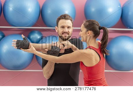 Young Man Helped By His Coach Doing Stretching Exrcises In A Gym. Selective Focus On The Woman.
