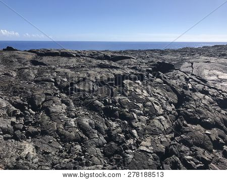 Dried Lava From Volcano National Park On The Big Island With Water In The Background
