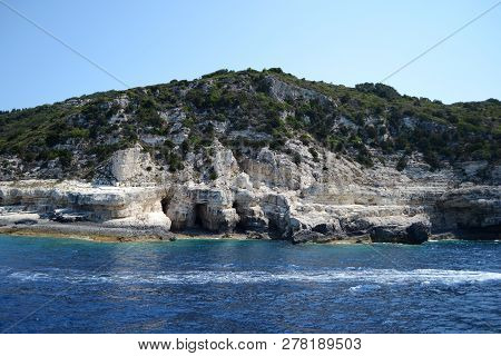 The Shore Of Paxos Island Seen From The Sea, With A Part Of The Blue Caves In The Front.