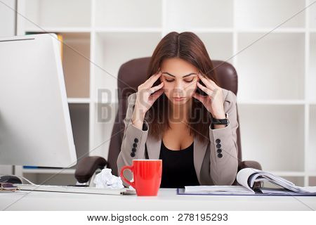 Headache And Stress At Work. Portrait Of Young Business Woman At Her Office
