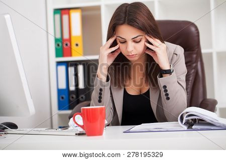 Headache And Stress At Work. Portrait Of Young Business Woman At Her Office