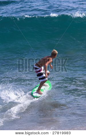 Mladý muž skimboarding v příboji na Balboa Beach, Kalifornie Balboa