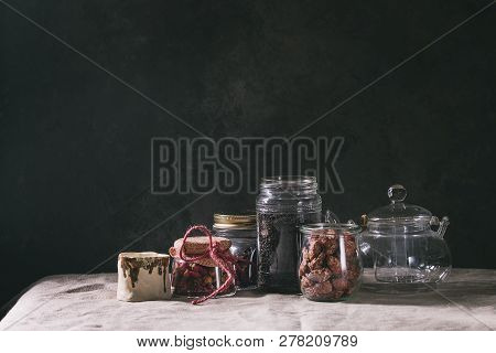 Tea Collection. Black Dry Tea In Jar, Rose Buds, Empty Glass Teapot, Cream Jug, Sweet Sugared Almond