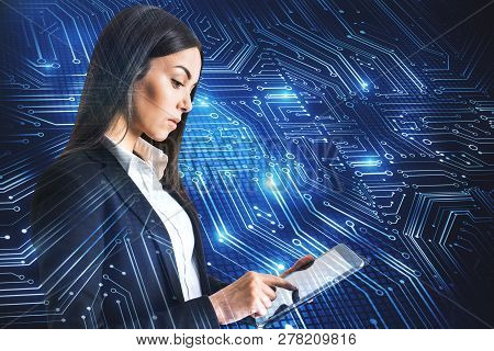 Attractive Young Businesswoman Using Tablet With Circuit. Technology And Computing Concept. Double E