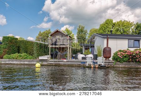 Loosdrecht, Netherlands - September 3 , 2017:  Wooden Playhous Next To A Mobile Homes On The Banks O