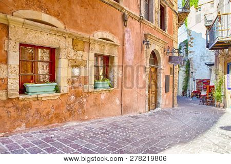 Tranquil And Empty Street Of Chania At Summer Time With Colorful Shutters At Windows And Flowers In 