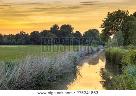 Landscape Scene Over River And Road At Sunset In Flat Agricultural Area In Groningen Province The Ne