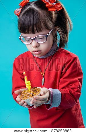 Interested Uncomprehended Little Girl Being Busy With Festive Cupcake