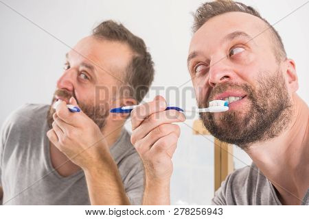 Funnny Guy Taking Care Of His Oral Hygiene, Brushing Teeth During Morning Bathroom Routine.