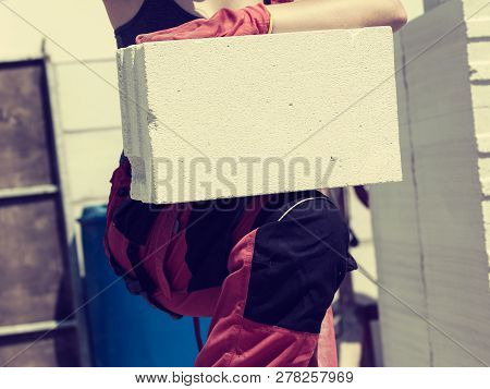 Unrecognizable Woman Working On Construction Site, Building House, Installing Gray Airbricks. Indust