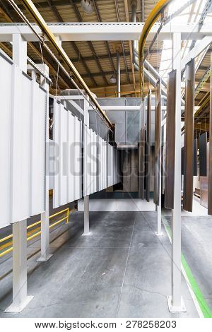 Powder Coating Line. Metal Panels Are Suspended On An Overhead Conveyor Line. Painting Products In A