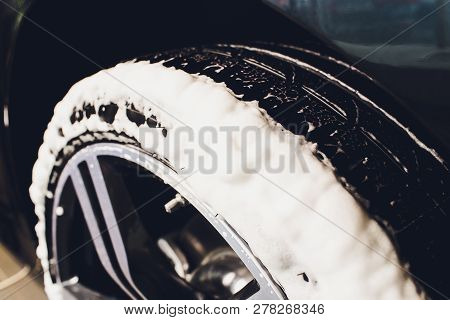 Car Care Or Car Detailing Process. Using Black Sponge To Washing The Tire. Blacker Rubber.