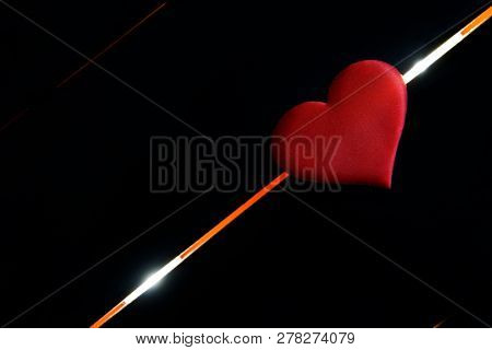 The Heart Lies On A Black Background And Glowing Diagonal Lines. The Fate Of Man, Life And Death. He