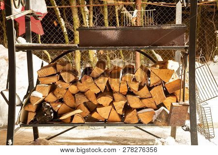 Birch Firewood Prepared For Bbq. Are Lying Under The Grill In Snow. Winter Night.