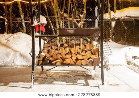 Birch Firewood Prepared For Bbq. Are Lying Under The Grill In Snow. Winter Night