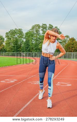 Athletic Woman On Running Track Has Side Cramps During Workout